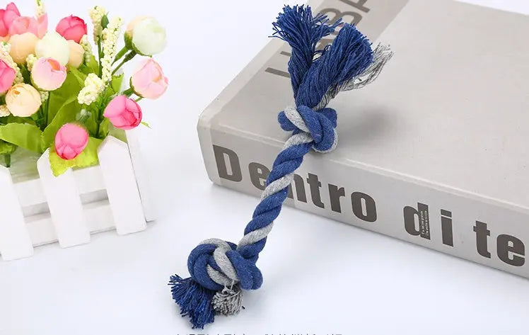 Dark blue cotton rope pet toy with knot design from Pethome placed on a book.