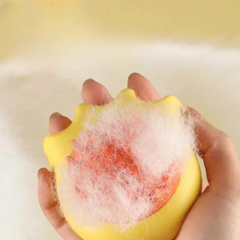 Pet bath brush with fur, held in hand.