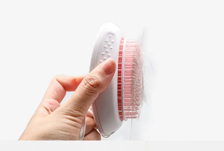 Hand using white ABS cat hair brush with plastic bristles.