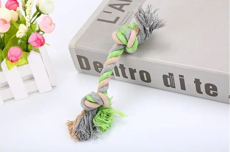 Rope pet toy made of cotton with knot design in green and beige.