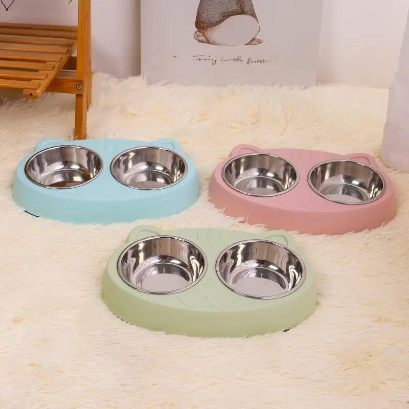 Cat face stainless steel bowls in blue, green, and pink for pet feeding.