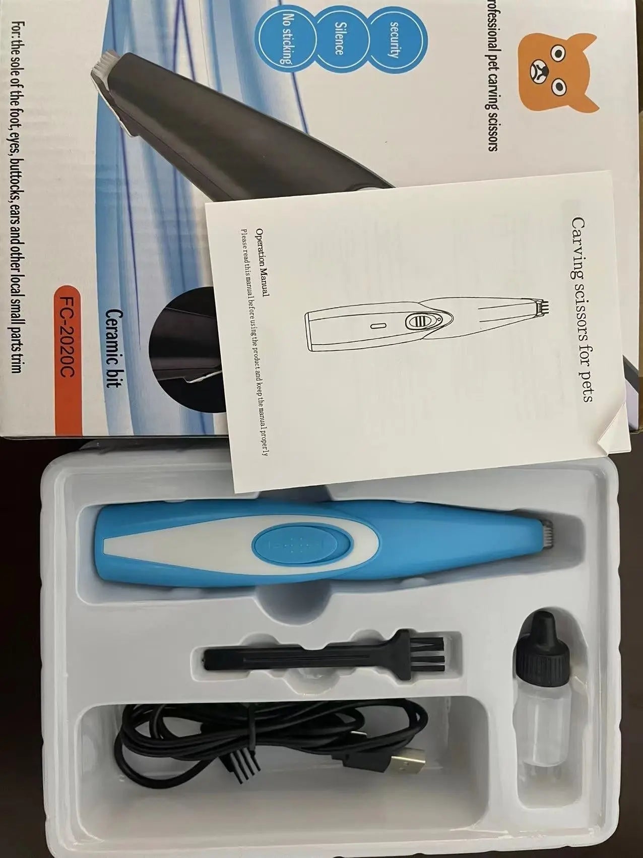 Pet hair clipper set with blue and white electric shaver, USB cable, brush, and oil bottle in packaging.