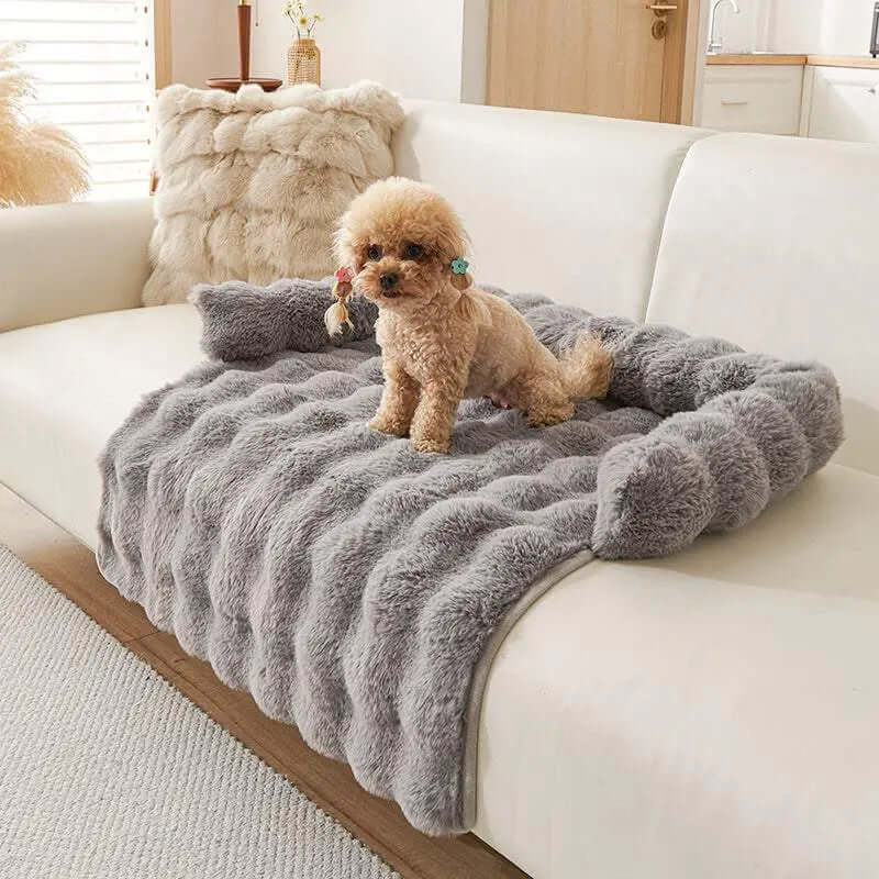 Plush gray dog mat on a couch with a small dog sitting on it.