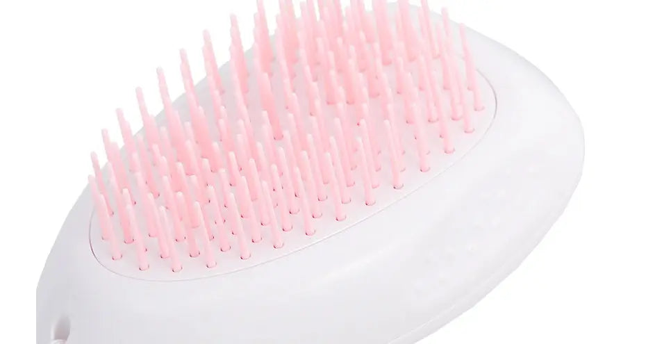 White brush with pink bristles for grooming cat hair.